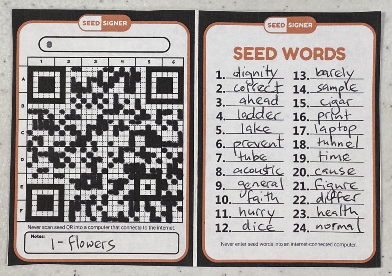 A printed card with a seed phrase written out and a hand-transcribed SeedQR