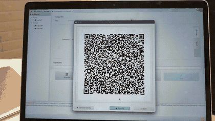A SeedSigner scanning an animated QR code from a computer screen, with a progress indicator filling